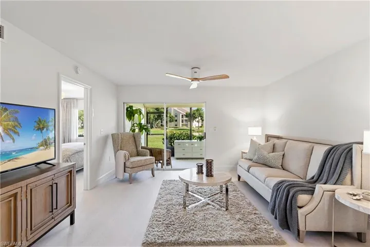 Living room featuring ceiling fan and light hardwood / wood-style flooring