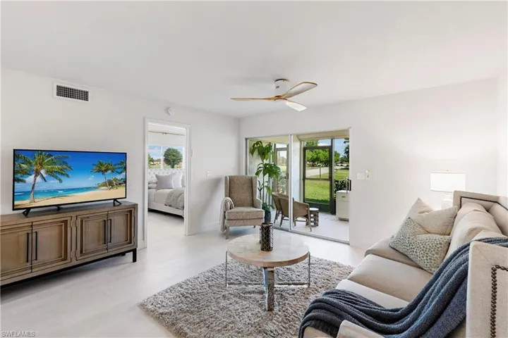 Living room with a healthy amount of sunlight, ceiling fan, and light hardwood / wood-style floors