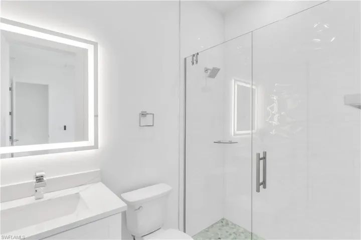 Bathroom with vanity, toilet, and a shower with door