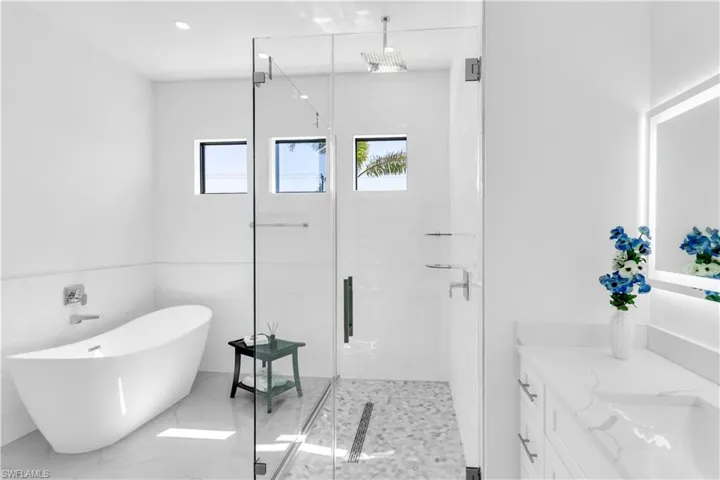 Bathroom featuring vanity and independent shower and bath