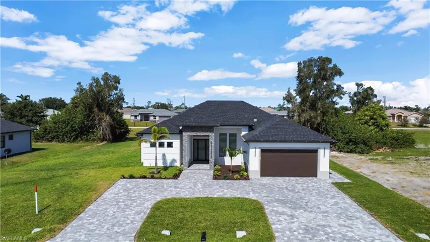 View of front of home with a front lawn and a garage
