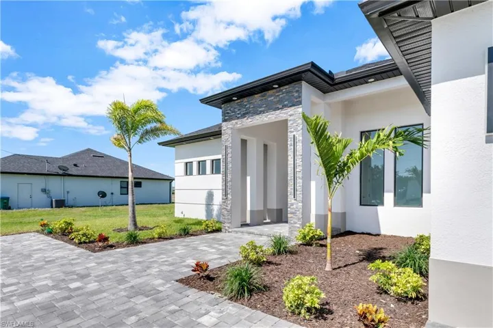 View of front of property with central AC unit and a front lawn