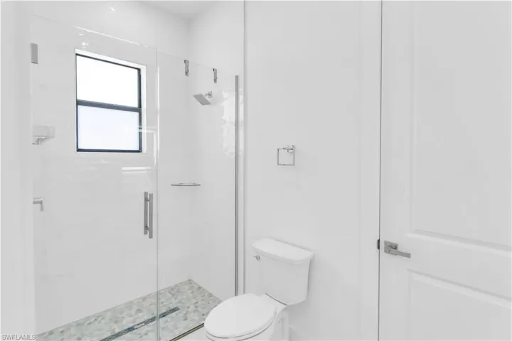 Bathroom with toilet and a shower with shower door