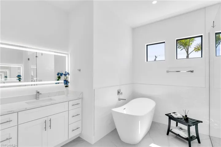 Bathroom with a bath, vanity, and tile walls