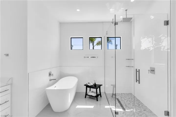 Bathroom featuring shower with separate bathtub and tile walls