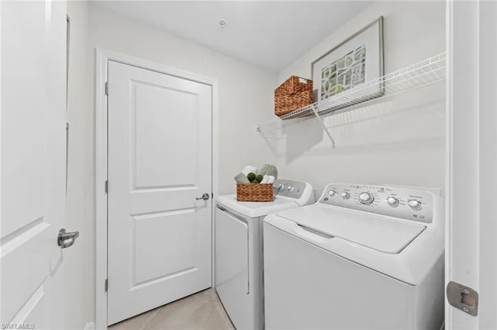 Laundry area featuring separate washer and dryer and light tile patterned flooring