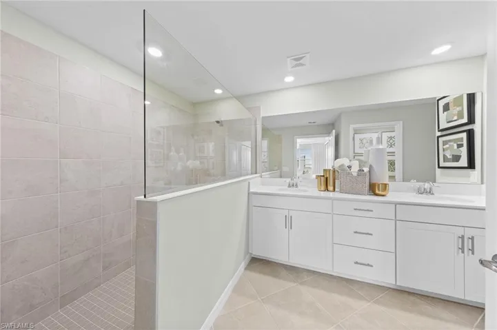 Bathroom with double vanity, walk in shower, light tile patterned floors, and recessed lighting