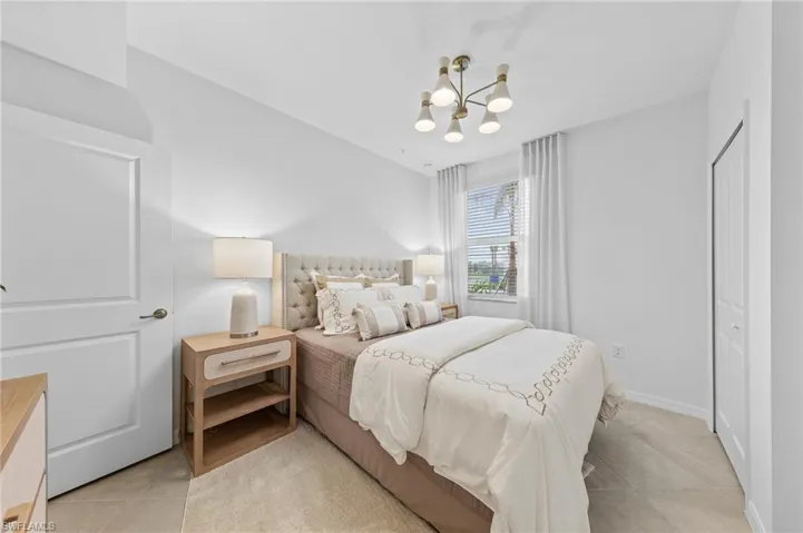 Bedroom featuring a chandelier, a closet, and light tile patterned flooring