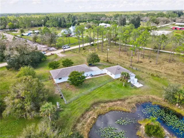 Birds eye view of property with a water view and a rural view