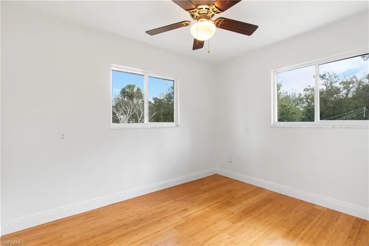 Spare room featuring plenty of natural light, ceiling fan, and light hardwood / wood-style flooring