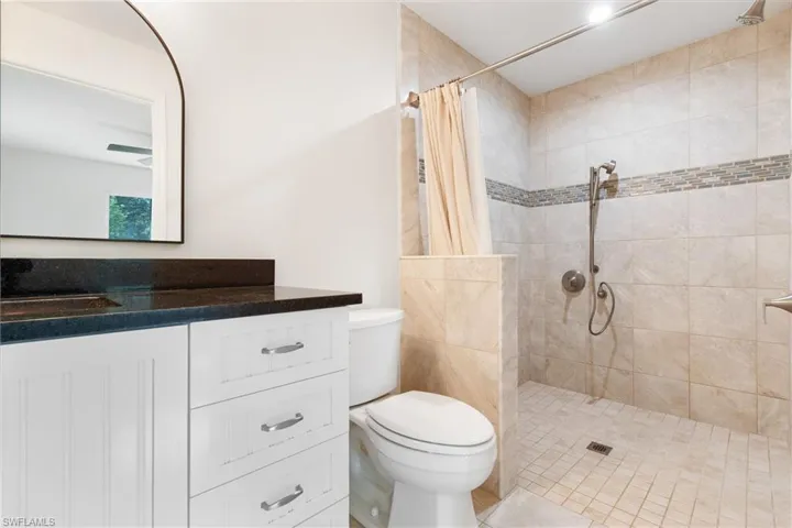 Bathroom featuring toilet, vanity, and a shower with shower curtain