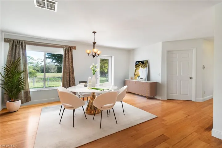 Dining room with light hardwood / wood-style floors and an inviting chandelier