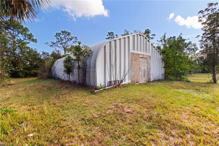 View of outdoor structure with a yard