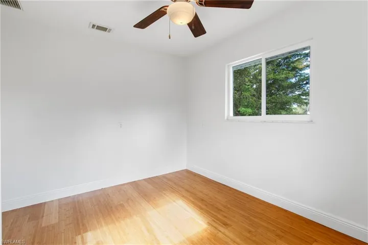 Unfurnished room featuring hardwood / wood-style flooring and ceiling fan