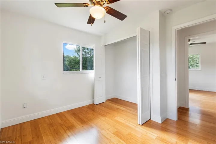 Unfurnished bedroom featuring ceiling fan, a closet, and light wood-type flooring