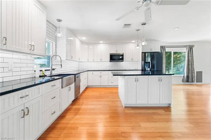 Kitchen featuring pendant lighting, white cabinets, and appliances with stainless steel finishes