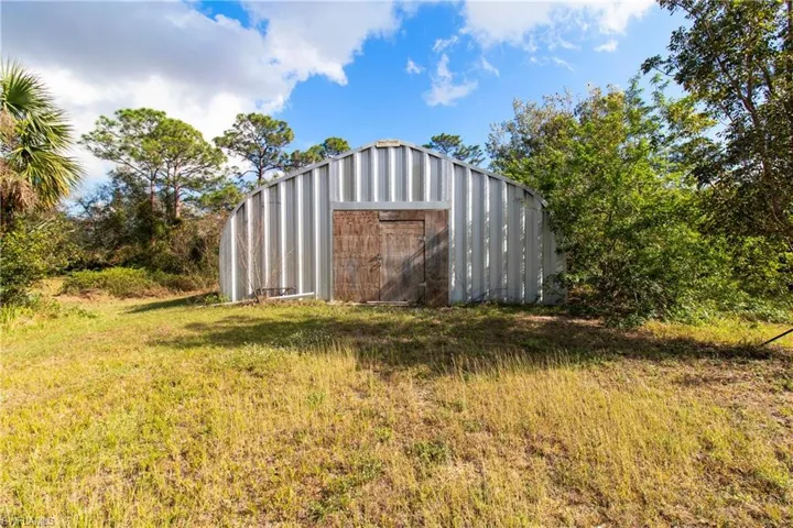 View of outbuilding featuring a lawn