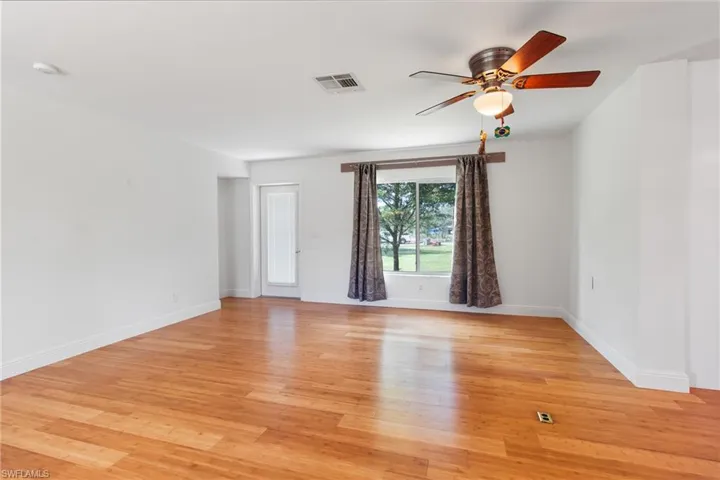 Living room with ceiling fan and light hardwood / wood-style flooring