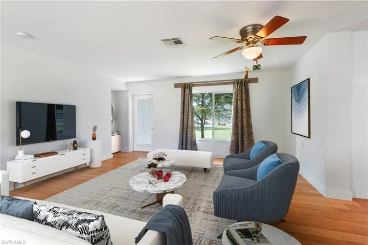 Living room with light wood-type flooring and ceiling fan