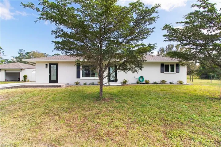 Ranch-style home featuring a front lawn