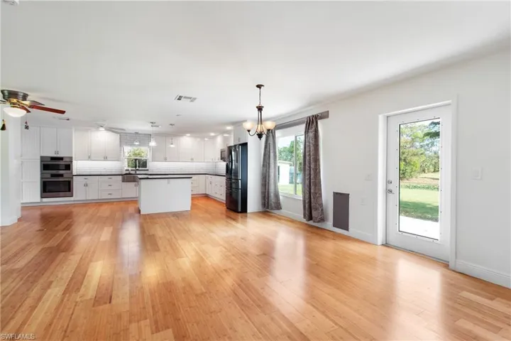 Kitchen featuring pendant lighting, a center island, white cabinetry, and tasteful backsplash