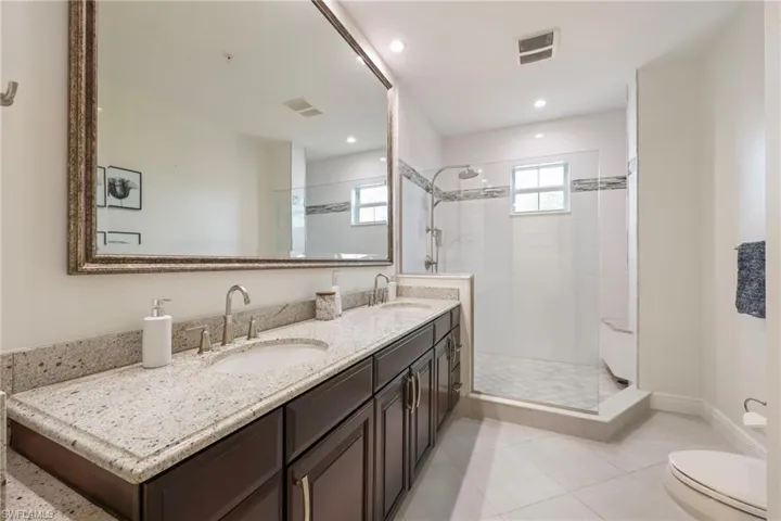 Guest bathroom with dual sinks and walk-in shower