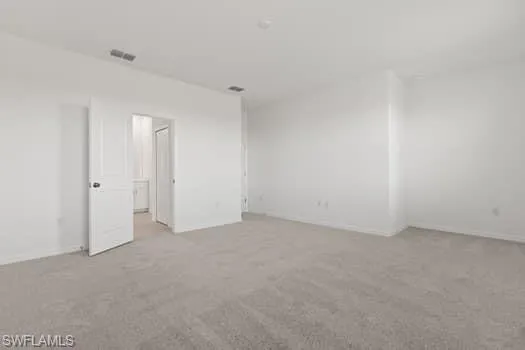 Carpeted spare room with baseboards