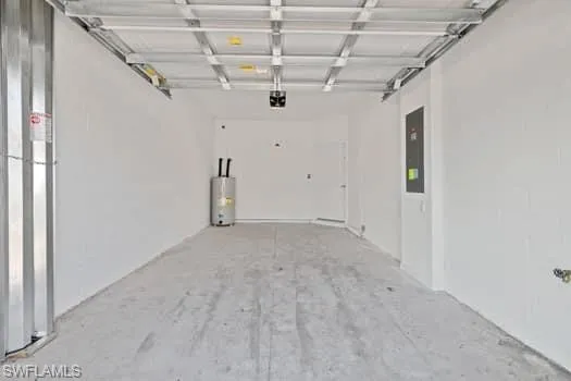 Garage featuring water heater, electric panel, and a garage door opener