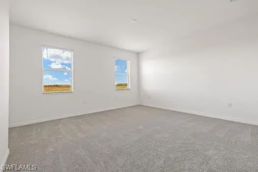 Carpeted spare room with healthy amount of natural light