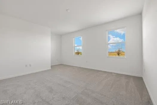 Empty room featuring carpet and baseboards
