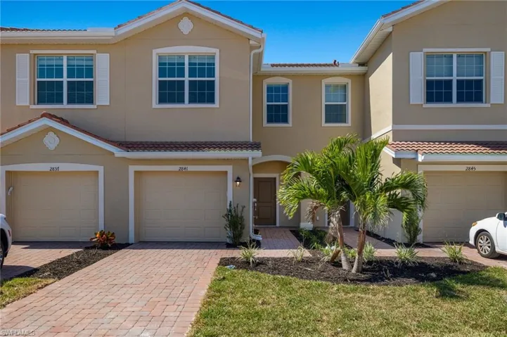 Multi unit property featuring stucco siding, decorative driveway, and an attached garage