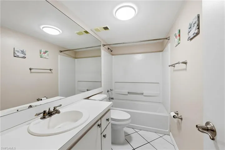 Guest Bathroom featuring vanity, bathtub / shower combination, and light tile patterned flooring