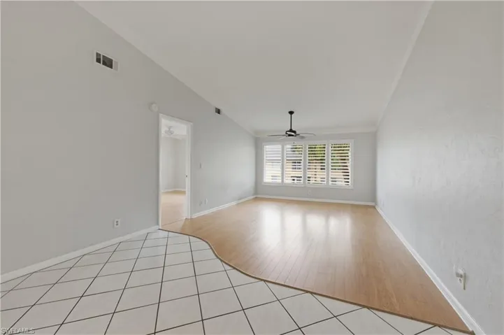 Great room with ornamental molding, light tile patterned floors, and a ceiling fan