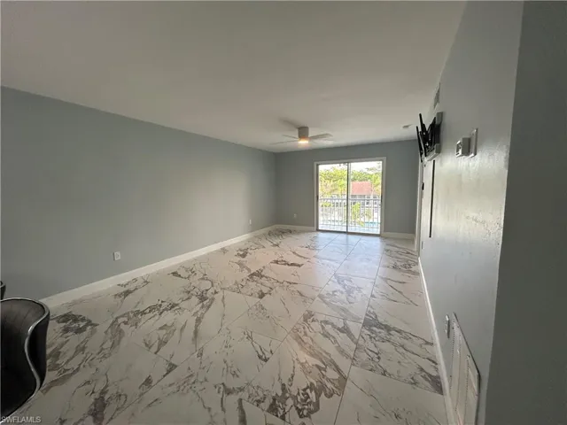 Open Living and Dining Rooms with sliding door leading to balcony