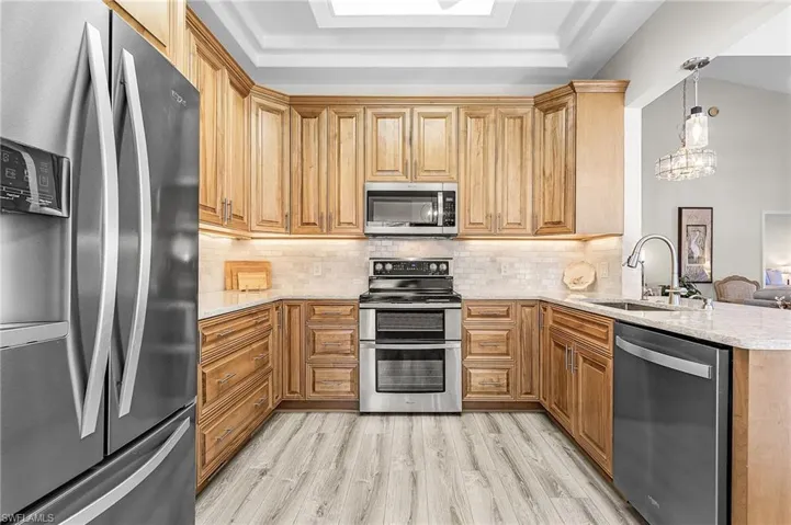 Incredible updated kitchen with stainless steel appliances, 42" wood cabinets, quartz counter tops, tile back splash, LVT flooring, pendant lighting.