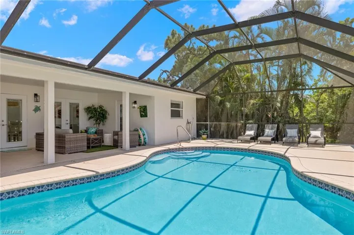 View of swimming pool featuring a lanai and a patio