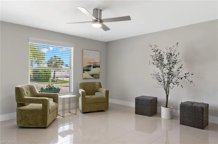 Living area featuring tile flooring and ceiling fan