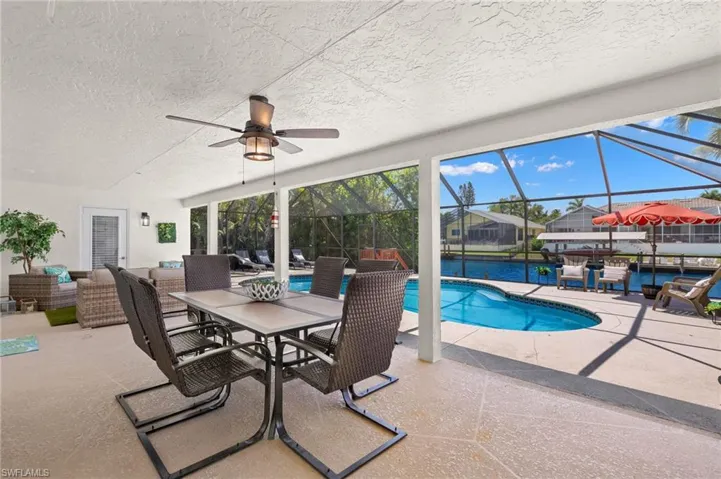 View of swimming pool with a patio area, glass enclosure, ceiling fan, and an outdoor living space