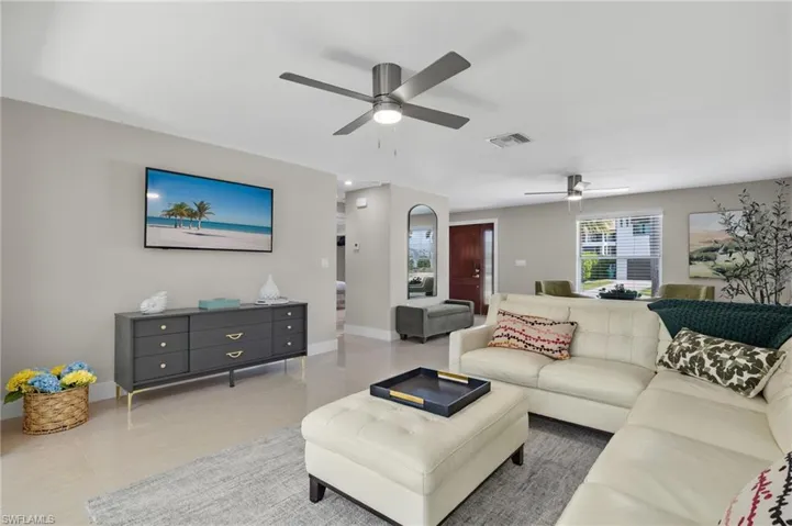 Living room featuring ceiling fan and light tile floors
