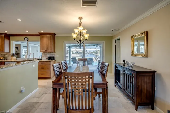 Dining room with suspended lighting and crown molding