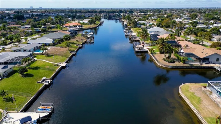 Aerial view of property and surrounding area featuring nearby suburban area
