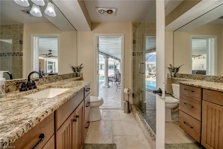 Bathroom featuring vanity, a shower stall, and ceiling fan
