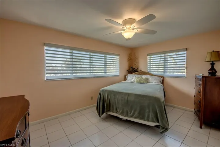 Bedroom with a ceiling fan and light tile patterned floors