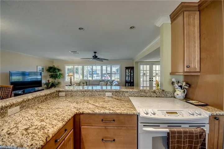 Kitchen with electric stove, open floor plan, light stone countertops, french doors, and healthy amount of natural light
