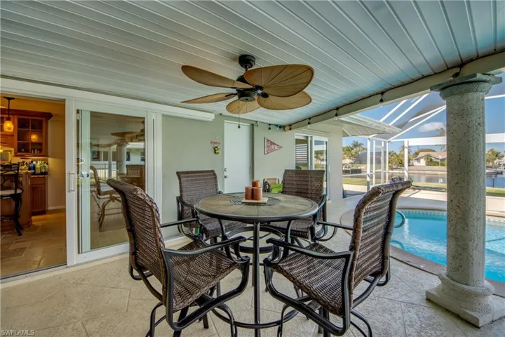 Sunroom / solarium featuring ceiling fan, outdoor dining space, a patio area, and a water view