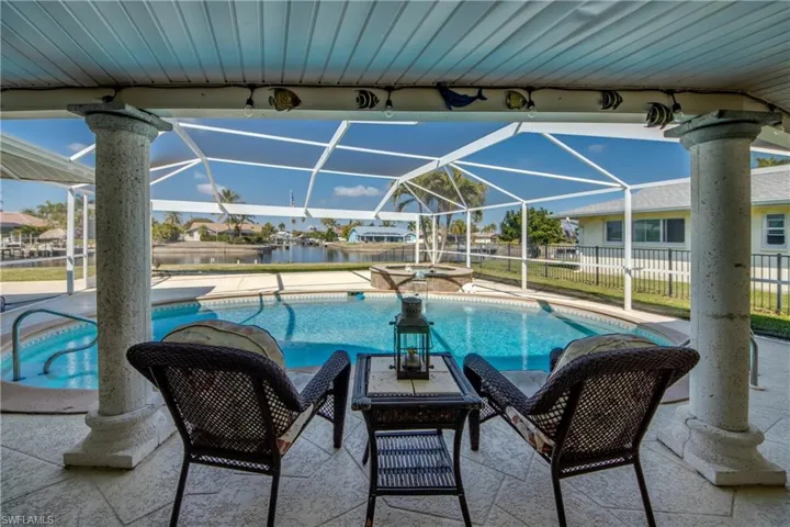 Integrated pool / spa with a patio area, glass enclosure, a sunroom, and a residential view