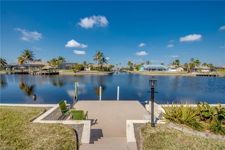 Dock area with a residential view, a water view, and a lawn