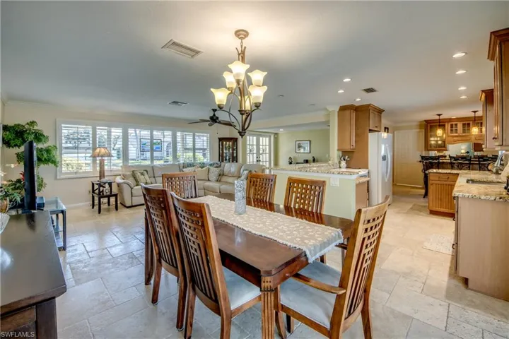 Dining room with stone tile floors, ceiling fan, and hanging lights