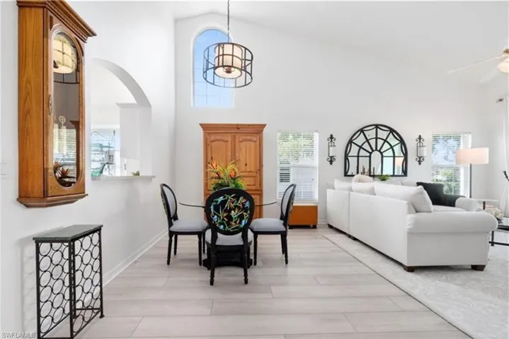 Dining space with arched walkways, high vaulted ceiling, and plenty of natural light