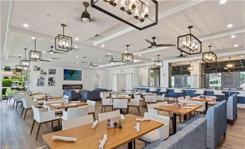 Dining space with a raised ceiling, recessed lighting, ceiling fan with notable chandelier, and wood finished floors